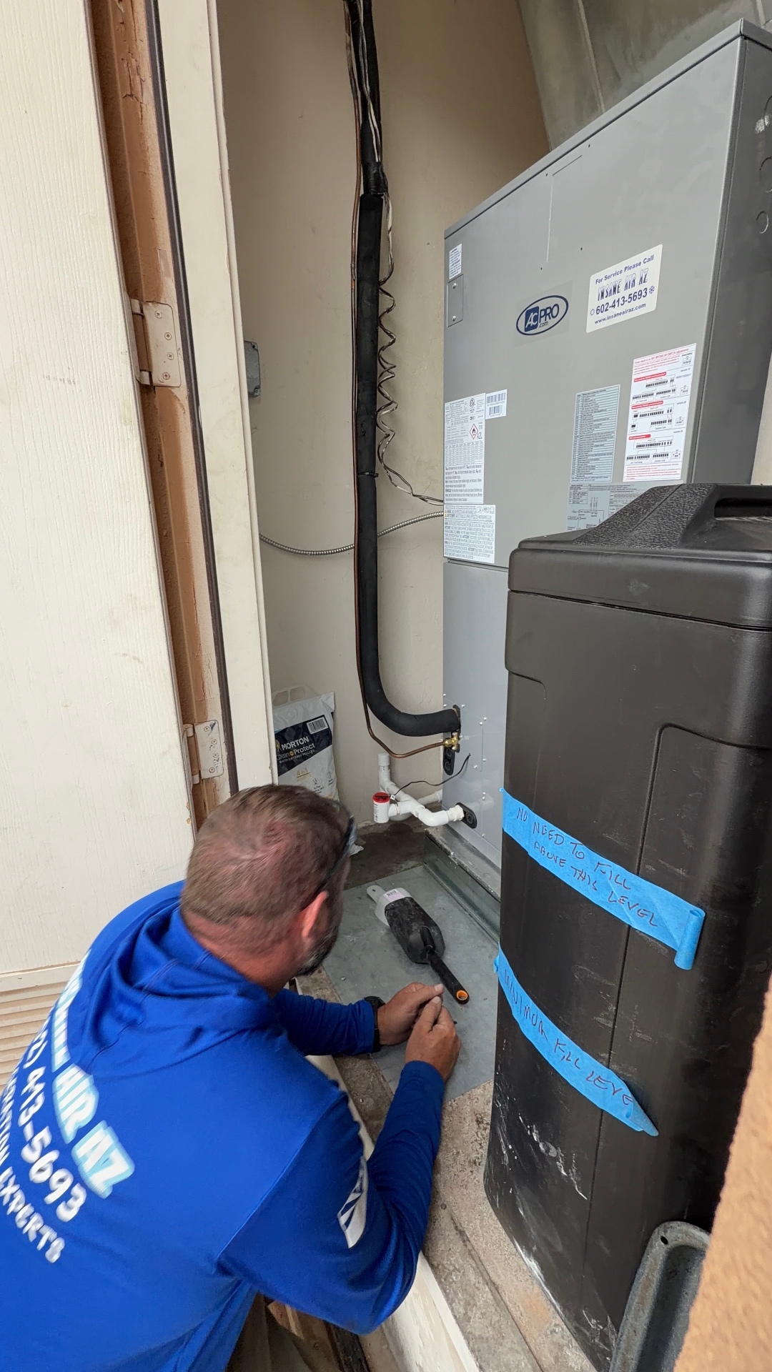 Insane Air technician servicing indoor HVAC equipment in a Valley home
